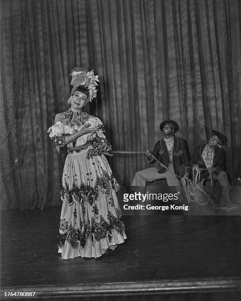 Two male dancers hold choreographer Katherine Dunham by a rope tied around her waist during a performance of 'A Caribbean Rhapsody' at the Prince of...