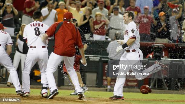 Paul Goldschmidt of the Arizona Diamondbacks is dowsed with water by teammates as he approaches home plate following his game-winning walk off home...