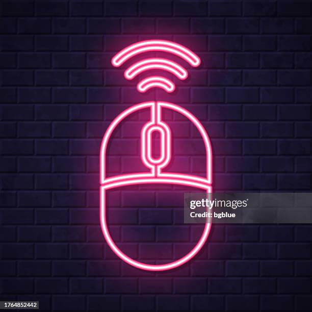 wireless computer mouse. glowing neon icon on brick wall background - computer office night stock illustrations
