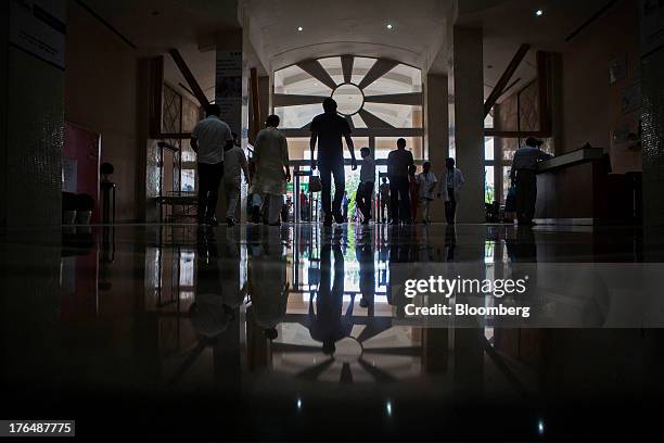 People walk through the lobby of the Indraprastha Apollo Hospitals facility, operated by Apollo Hospitals Enterprise Ltd., in New Delhi, India, on...