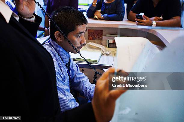 An employees processes payments at a service counter in the Wellness Center of the Indraprastha Apollo Hospitals facility, operated by Apollo...