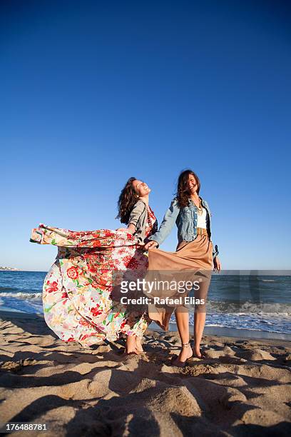 two women on the beach - woman long dress beach stock pictures, royalty-free photos & images