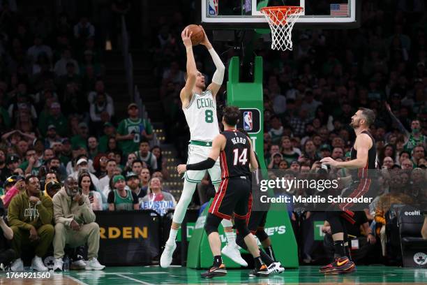 Kristaps Porzingis of the Boston Celtics jumps to the basket over Tyler Herro, Kyle Lowry and Kevin Love of the Miami Heat at TD Garden on October...