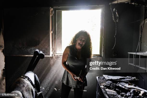 Kibbutz Nir Oz resident Hadas Kalderon, whose children have been taken hostage, and her mother and niece killed, breaks down in tears while looking...