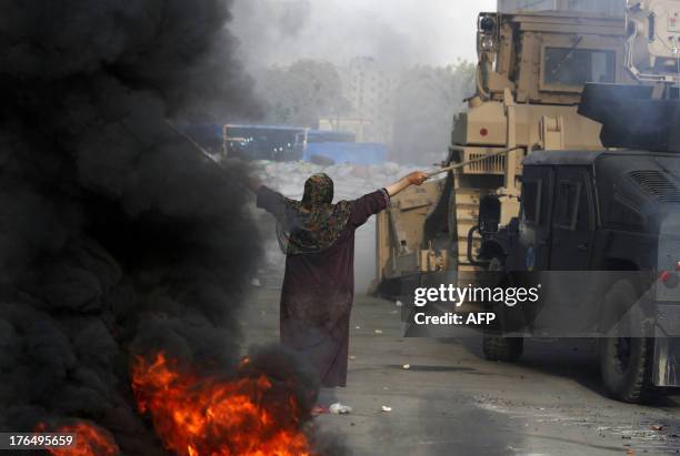 An Egyptian woman tries to stop a military bulldozer from going forward during clashes that broke out as Egyptian security forces moved in to...