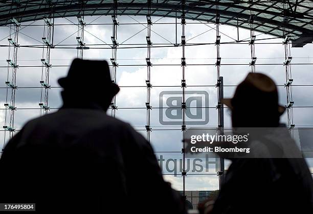 Traveler gestures as the Deutsche Bahn AG logo is displayed on the windows of Berlin Central Station, also known as Hauptbahnhof, in Berlin, Germany,...