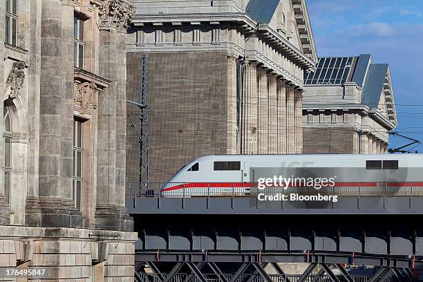 An InterCity Express train operated by Deutsche Bahn AG passes over a bridge spanning the River Spree between the Pergamon Museum, right, and Bode...