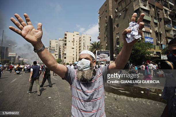 Supporter of Egypt's ousted president Mohamed Morsi gestures during clashes with riot police on a street leading to Rabaa al-Adawiya square in Cairo...