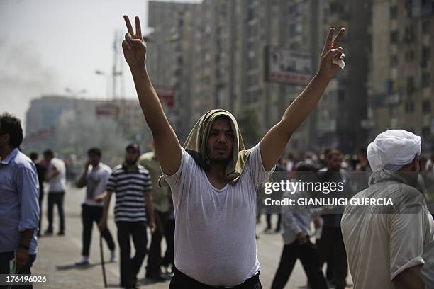 Supporter of Egypt's ousted president Mohamed Morsi gestures during clashes with riot police on a street leading to Rabaa al-Adawiya square in Cairo...