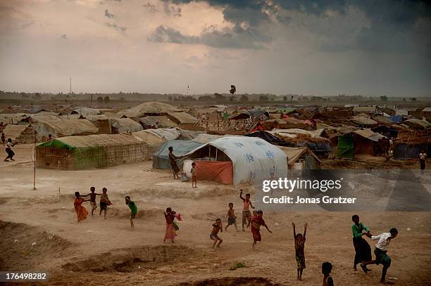 Group of Rohingya children play in an open space whilst people in the camp try to protect their tents against the strong winds that sweep across the...