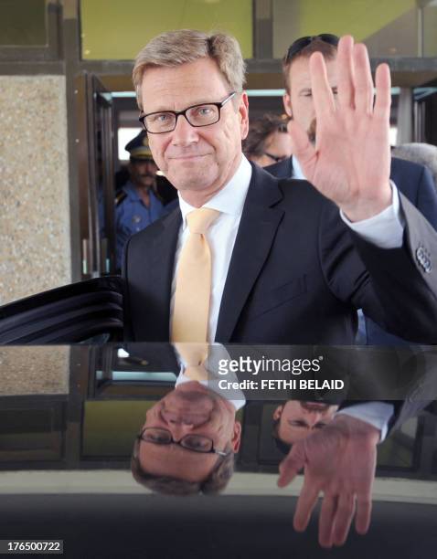 German Foreign Minister Guido Westerwelle waves as leaves Tunis airport for a meeting with his Tunisian counterpart on August 14, 2013 in Tunis....
