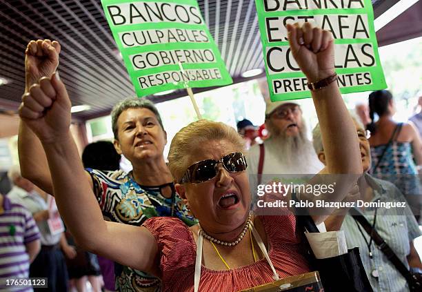 Protesters affected by preference shares shout slogans after PP General Secretary Maria Dolores de Cospedal left the Spanish High Court on August 14,...