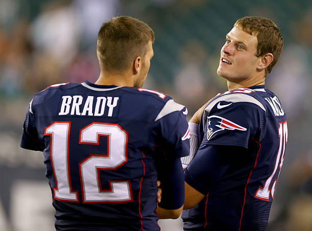 Ryan Mallett of the New England Patriots talks with teammate Tom Brady in the second half against the Philadelphia Eagles on August 9, 2013 at...