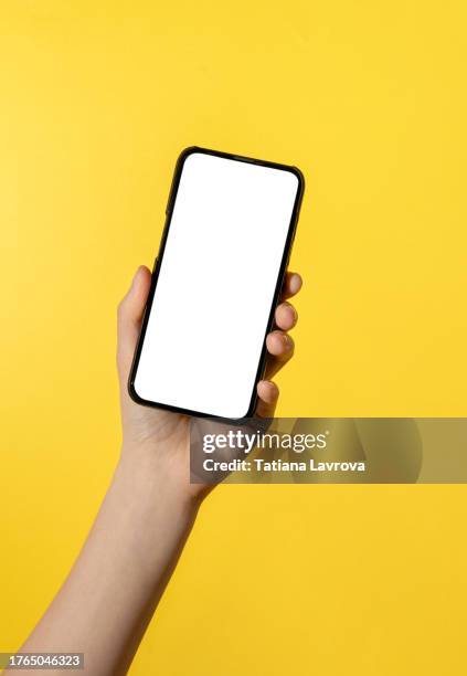 beautiful female hands with natural manicure holding smart phone with blank isolated white screen and space for text. surfing the internet, online shopping, using chat bot, artificial intelligence and modern technologies of the future - hand holding iphone stock pictures, royalty-free photos & images