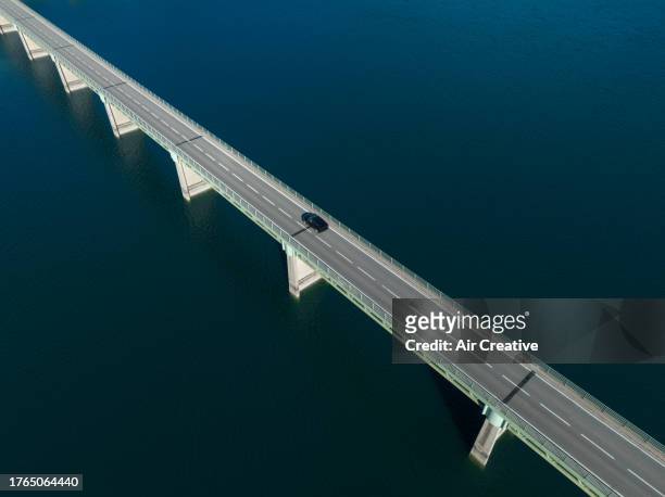 drone image of a single car on a road bridge crossing a lake, var, france - division 1 個照片及圖片檔