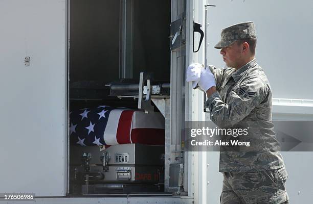 Air Force Senior Airman Christopher Cox closes the doors of the transfer vehicle during a dignified transfer at Dover Air Force Base August 14, 2013...