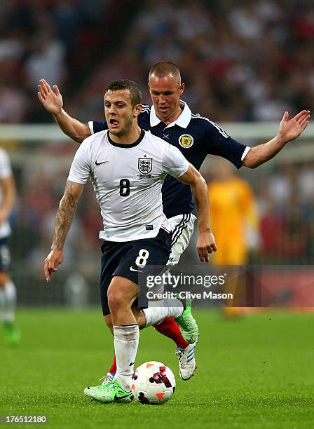 Jack Wilshere of England resists a challenge from Kenny Miller of Scotland during the International Friendly match between England and Scotland at...