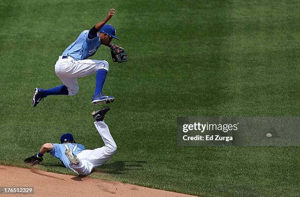 Alcides Escobar of the Kansas City Royals leaps over Chris Getz as they chase a hit by Justin Ruggiano of the Miami Marlins in the fourth inning at...