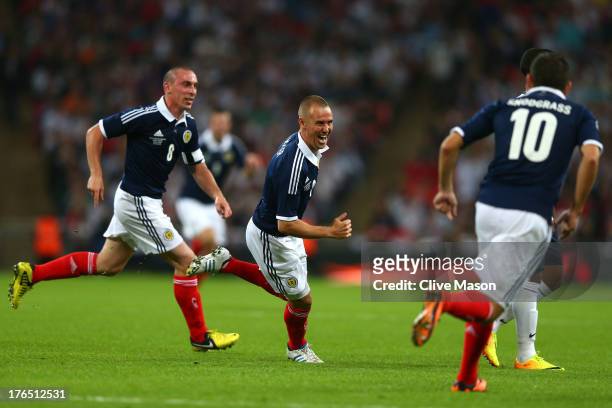 Kenny Miller of Scotland celebrates with team-mates Scott Brown of Scotland and Robert Snodgrass of Scotland after scoring a goal during the...