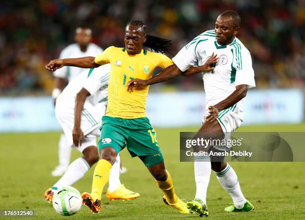 Reneilwe Letsholonyane of South Africa holds off Sunday Mba of Nigeria during the 2013 Nelson Mandela Challenge match between South Africa and...