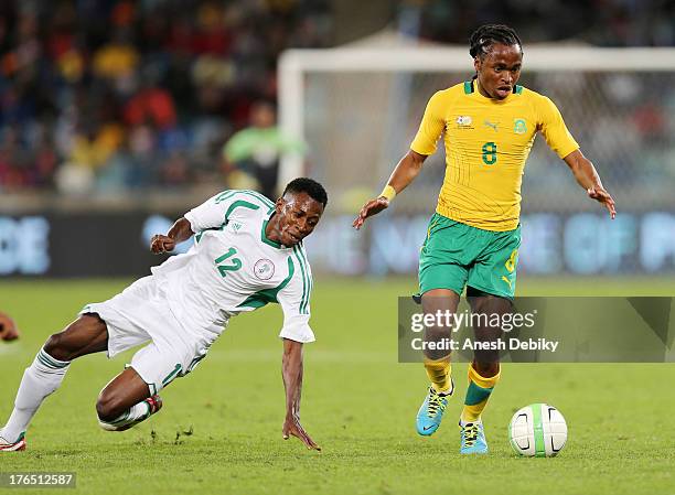 Siphiwe Tshabalala of South Africa goes around Nnamadi Oduamadi of Nigeria during the 2013 Nelson Mandela Challenge match between South Africa and...