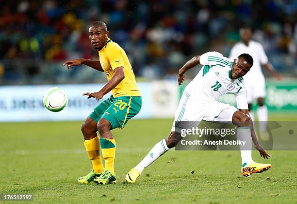 Thulani Hlatshwayo of South Africa loses the ball to Obinna Nsofor of Nigeria during the 2013 Nelson Mandela Challenge match between South Africa and...