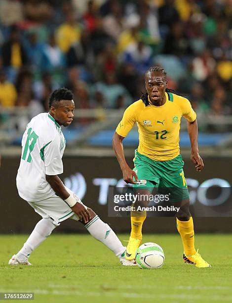 Reneilwe Letsholonyane of South Africa beats Ogenyi Onazi of Nigeria to the ball during the 2013 Nelson Mandela Challenge match between South Africa...