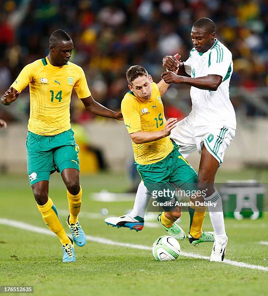Dean Furman of South Africa is bundled off the ball by Shola Ameobi of Nigeria during the 2013 Nelson Mandela Challenge match between South Africa...