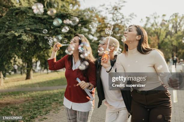 blowing soap balloons is fun - blowing up balloon stock pictures, royalty-free photos & images