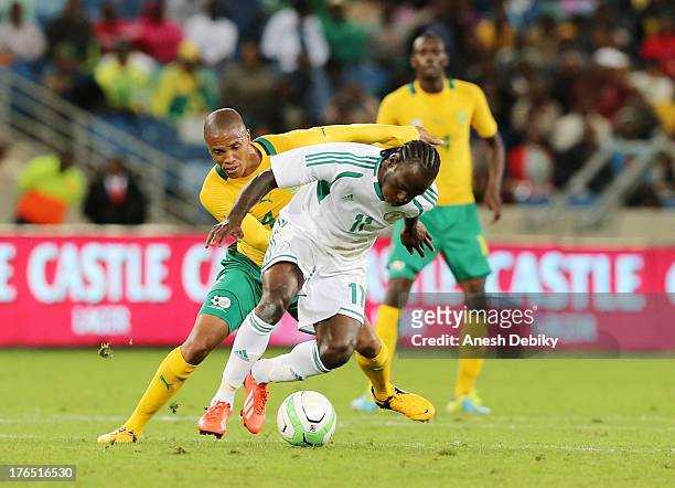 Thabo Nthethe battles Victor Moses of Nigeria during the 2013 Nelson Mandela Challenge match between South Africa and Nigeria at Moses Mabhida...