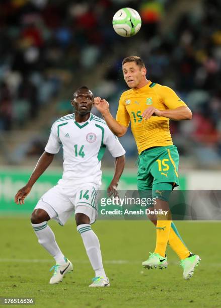 Dean Furman of South Africa heads the ball away from Uche Nwofor of Nigeria during the 2013 Nelson Mandela Challenge match between South Africa and...