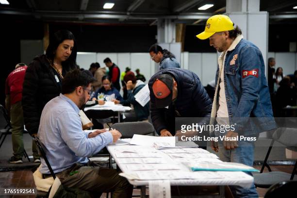 Members of the electoral jury count votes and discard all unused electoral materials during Colombia's regional elections to choose the new Mayors,...