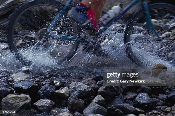 Mountain biking, man riding through stream, low section