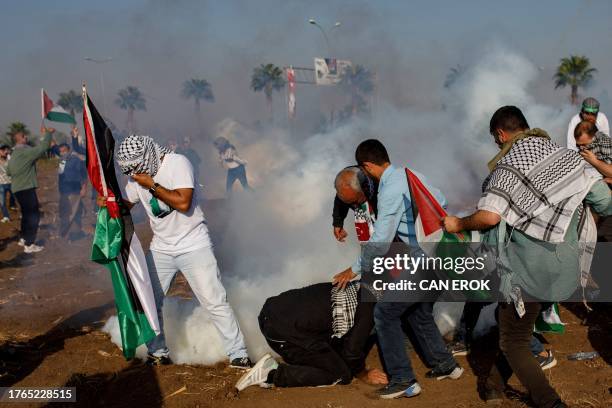 Protestors walk amid tear gas fired by Turkish anti-riot police during a Pro-Palestinian demonstration against the US Secretary of State's visit to...