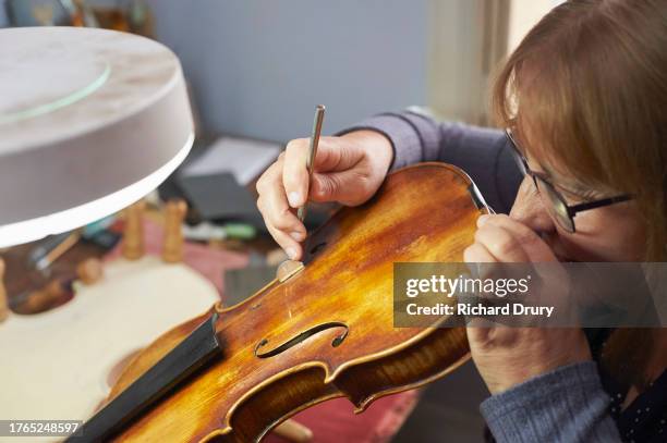 violin maker in her workshop - violin family stock pictures, royalty-free photos & images