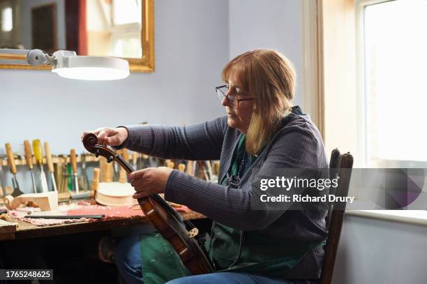 violin maker in her workshop - violin family stock pictures, royalty-free photos & images