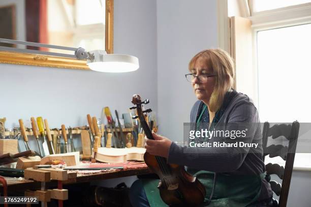 violin maker in her workshop - violin family stock pictures, royalty-free photos & images