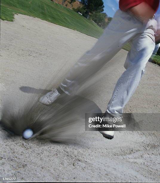 Golf, player striking ball in bunker,low section