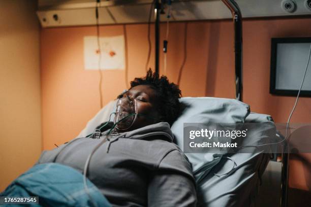 critical patient with oxygen mask sleeping while reclining on bed in hospital - gasmask bildbanksfoton och bilder