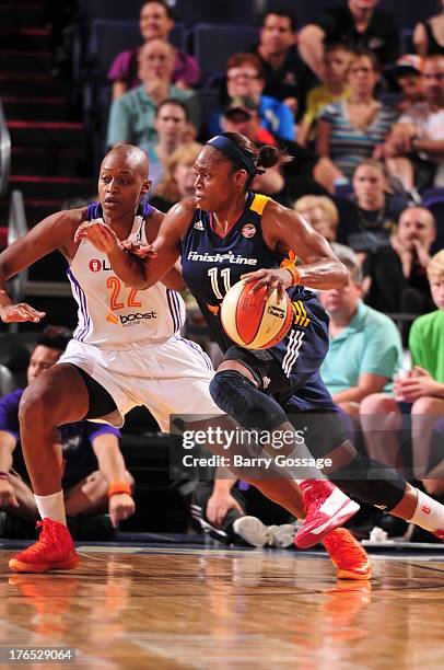 Karima Christmas of the Indiana Fever drives against Charde Houston of the Phoenix Mercury on August 14, 2013 at U.S. Airways Center in Phoenix,...