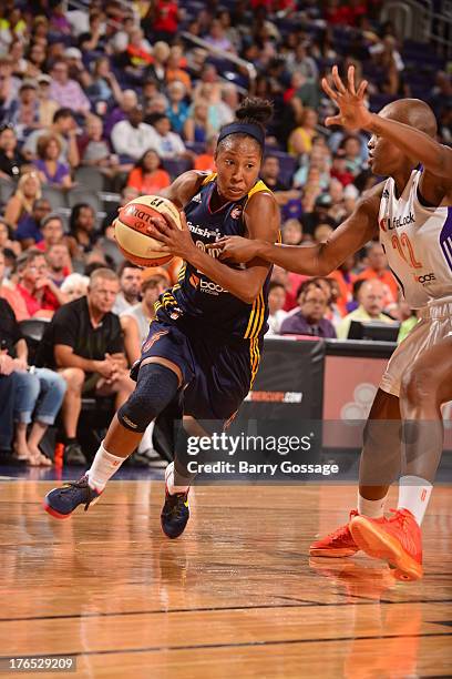 Briann January of the Indiana Fever drives against Charde Houston of the Phoenix Mercury on August 14, 2013 at U.S. Airways Center in Phoenix,...