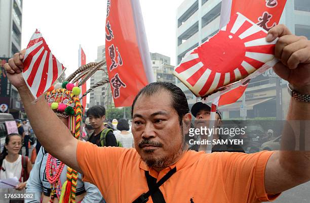 Protester tears apart of a Japan military flag during a demonstration to mark Japan's World War II surrender, in front of the Japan Interchange...