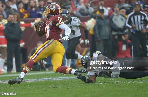 December 9: Washington Redskins quarterback Robert Griffin III eludes Baltimore Ravens free safety Ed Reed duyring a 3rd quarter keeper at FedEx...