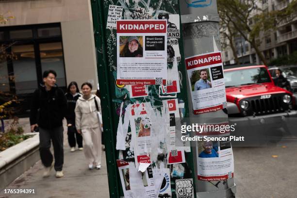Posters of some of those kidnapped by Hamas in Israeli are displayed on a pole outside of New York University as tensions between supporters of...