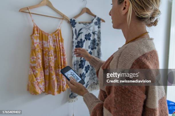 woman taking picture of her used clothes, she is selling her clothing online - secondhand försäljning bildbanksfoton och bilder