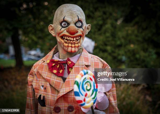 a halloween animatronic of scary clown holding a lollipop. - ugly clowns stockfoto's en -beelden