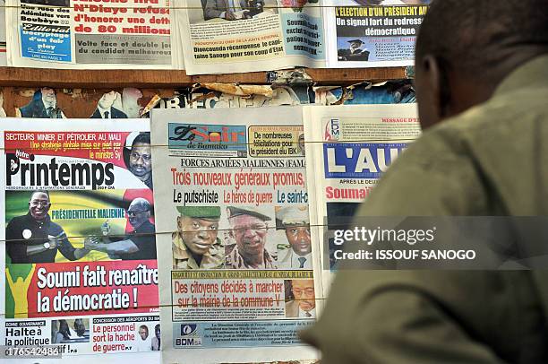 Man looks at the front pages of newspapers on August 15, 2013 in Bamako showing the leaders of the coup including Captain Amadou Sanogo that ousted...