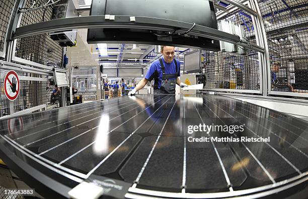 System administrator Holm Goehler checks a finished solar energy modul in the assembly line at the Solarworld plant on August 14, 2013 in Freiberg,...