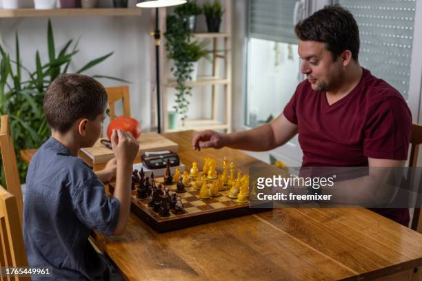 boy playing chess with big brother - chess timer stock pictures, royalty-free photos & images