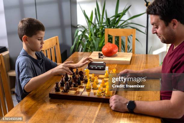 boy playing chess with big brother - chess timer stock pictures, royalty-free photos & images